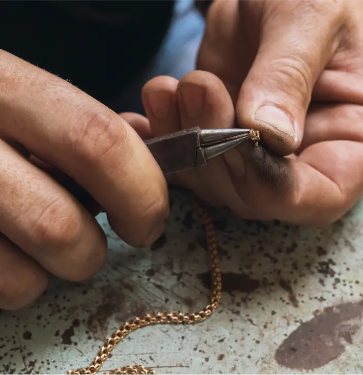 jeweler-repairs-gold-chain-corrects-lock-with-pliers-close-up 3